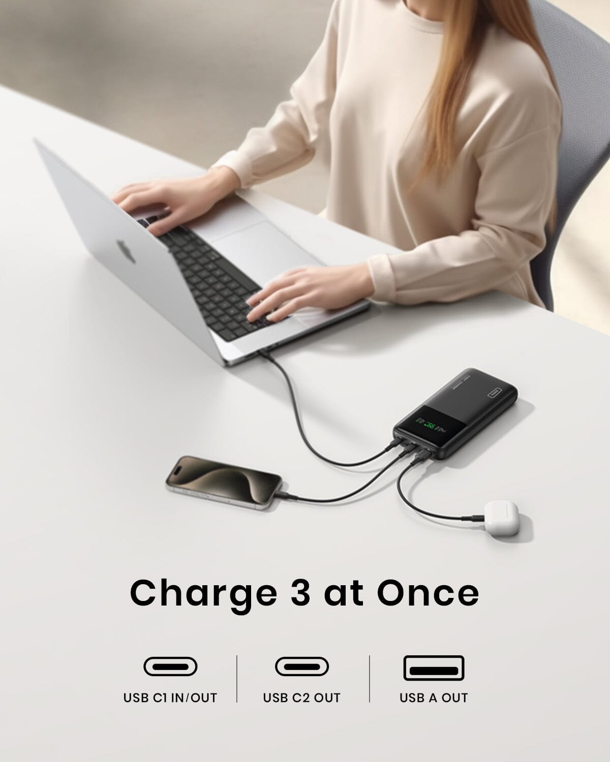 INIU B64 power bank charging three devices at once: laptop, phone, and earbuds. Features 3 charging ports.